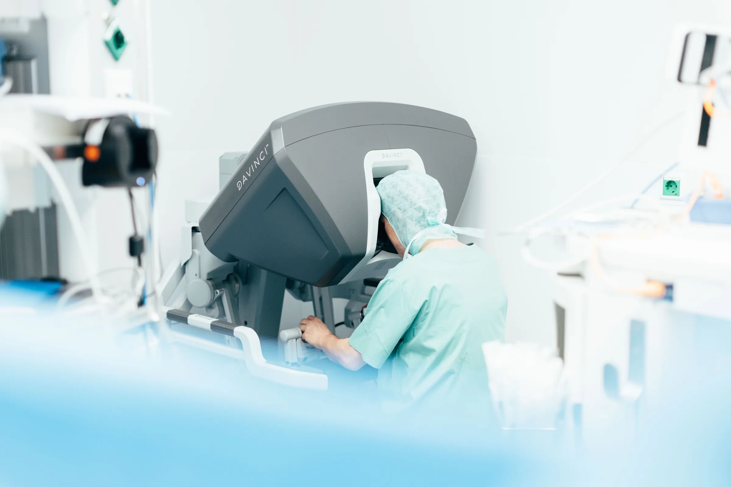 Der Operateur sitzt an der Steuerkonsole des da Vinci Systems, von hinten aufgenommen.