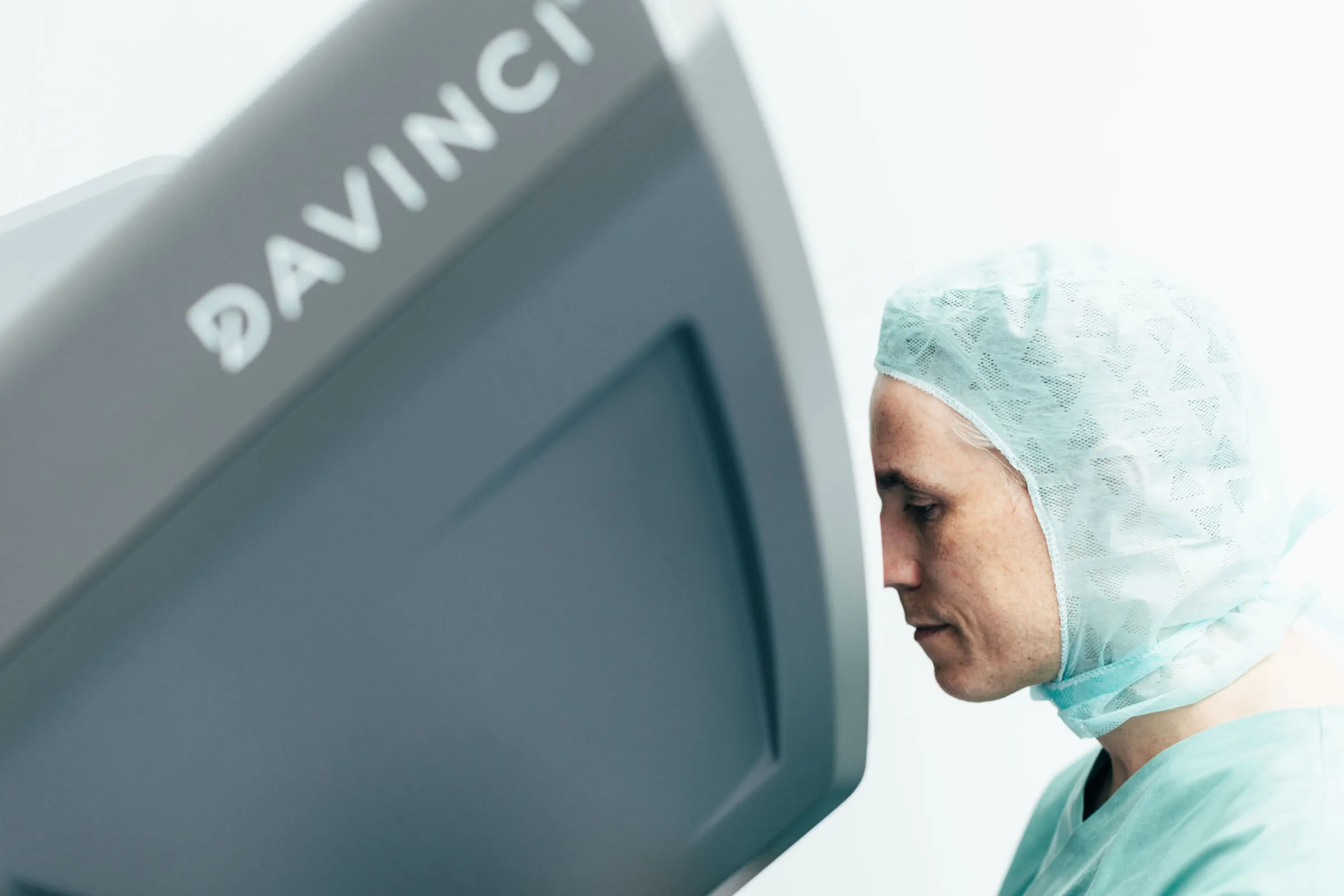 PD Dr. Leyh-Bannurah im Operationssaal, im Profil neben der Steuerkonsole des da Vinci Systems.
