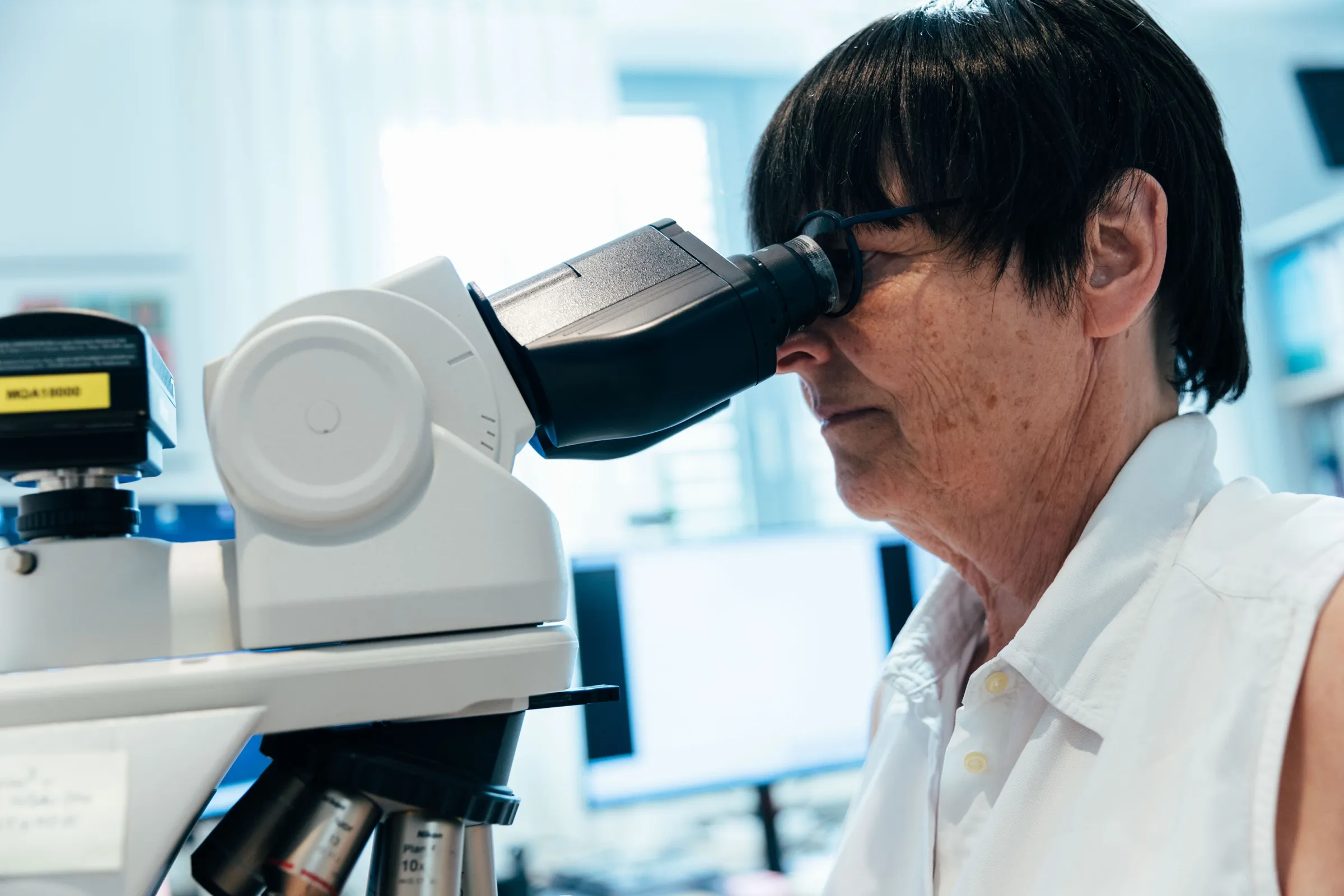 Fachärztin für Pathologie am Mikroskop bei der Beurteilung eines Gewebeschnitts.