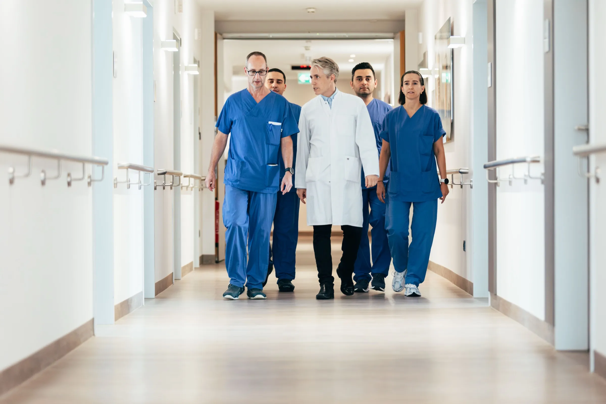 Das Team der Klinik für Urologie geht nebeneinander über den Stationsflur.